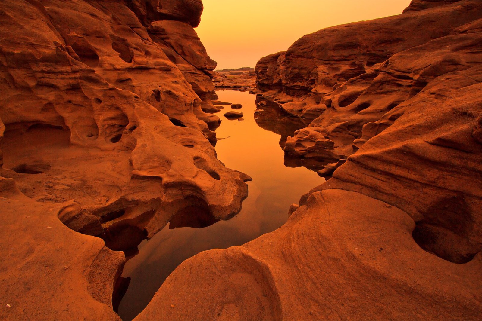 Clear rock pool cradled by glowing red sandstone in the Arizona desert