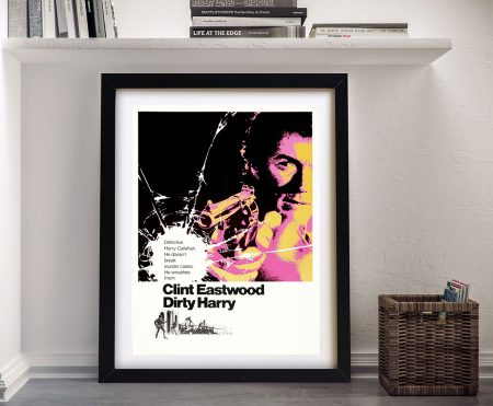 Framed Dirty Harry movie poster featuring Clint Eastwood with revolver in pink and yellow pop art style against white wall