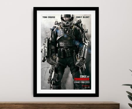 Edge of Tomorrow framed movie poster featuring Tom Cruise in mechanised exo-suit armour displayed on neutral grey wall above timber console