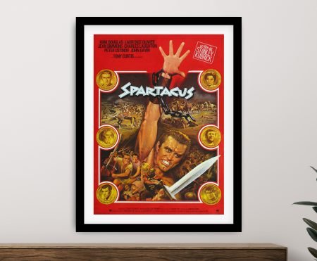 Framed Spartacus movie poster with bold red background and Kirk Douglas, displayed on a light grey wall above timber console
