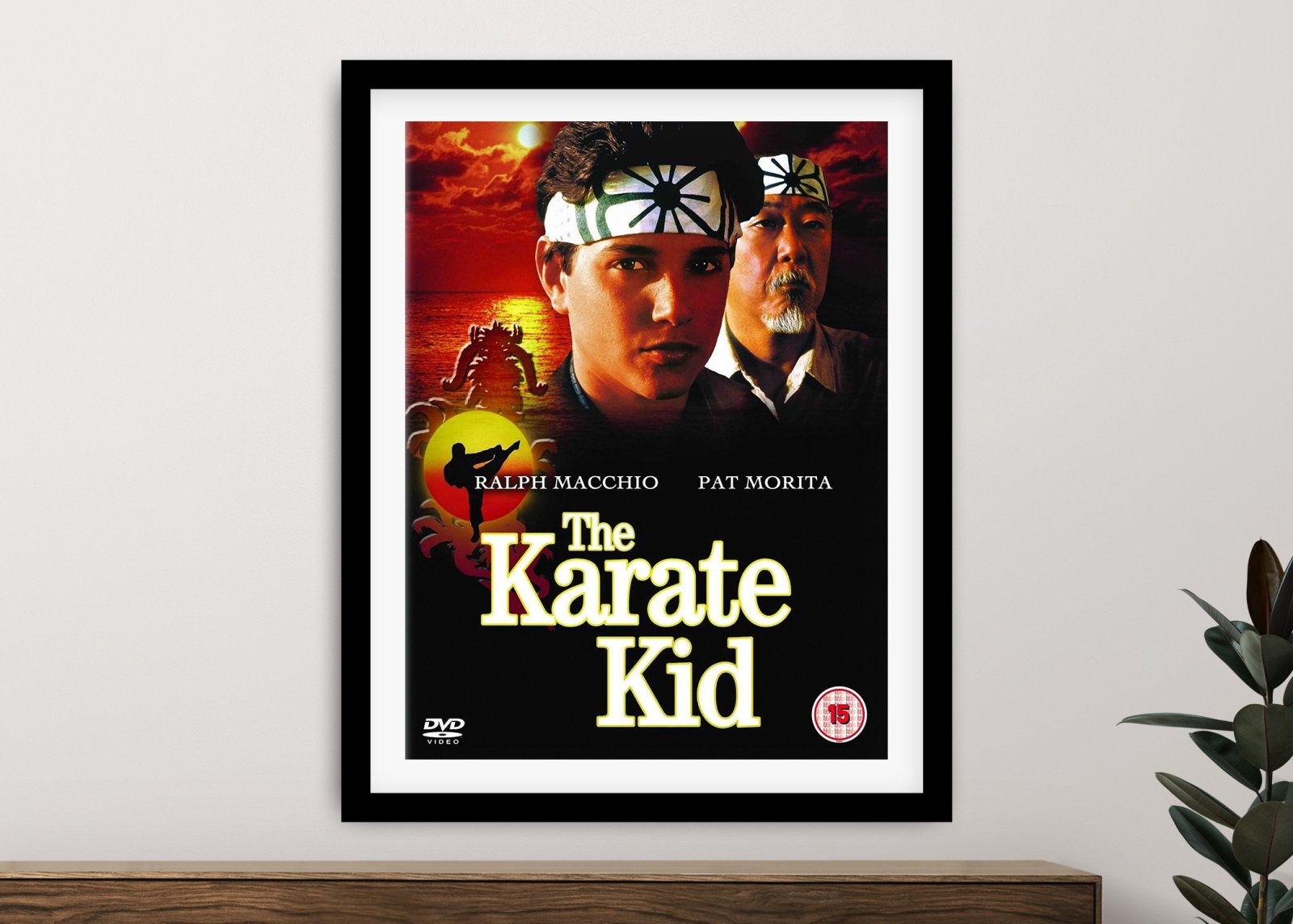 The Karate Kid framed movie poster featuring Ralph Macchio and Pat Morita above a fiery red sunset on a neutral living room wall