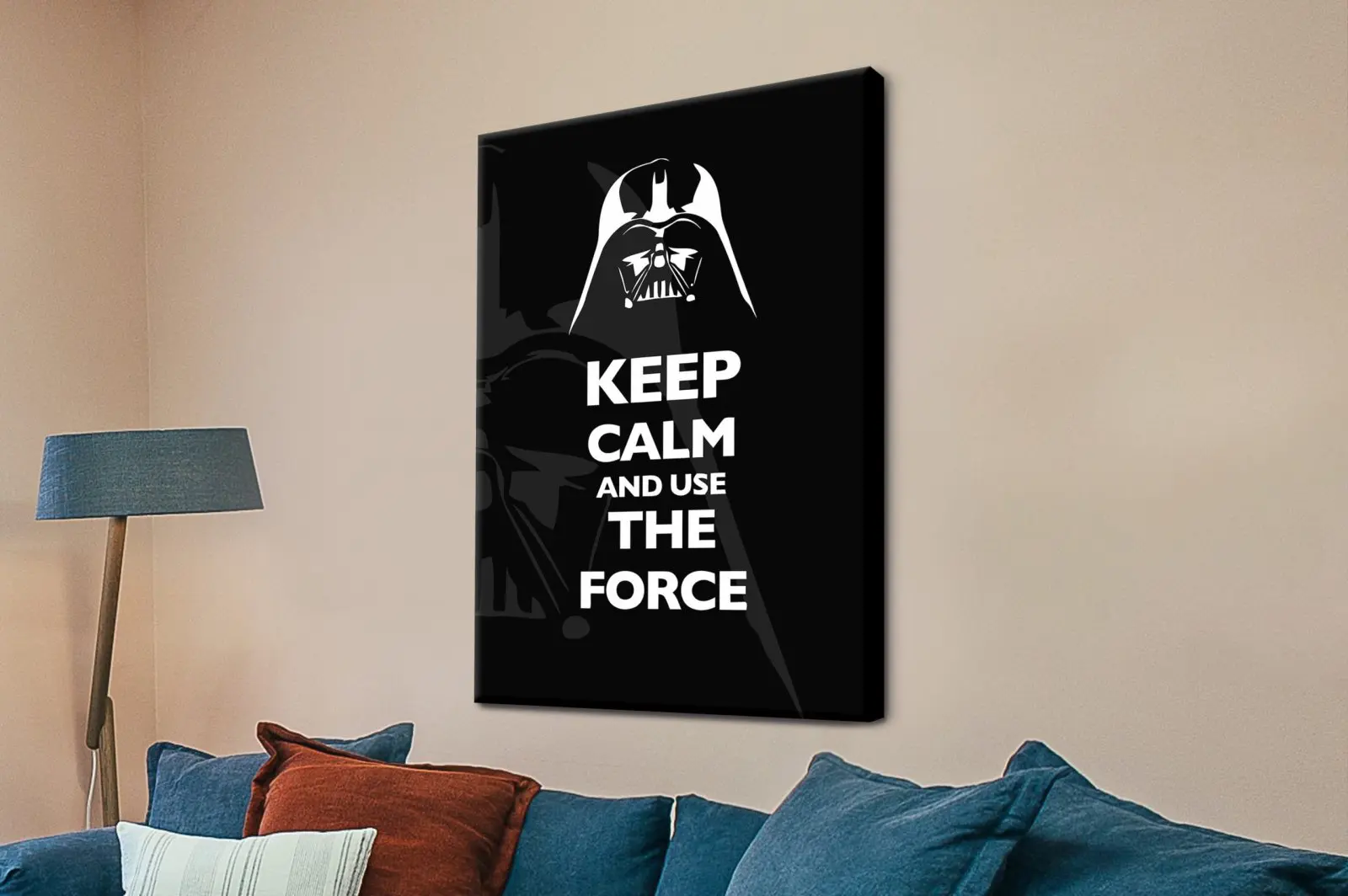 Keep Calm and Use the Force Darth Vader canvas print on a beige wall above a navy sofa with rust cushion and floor lamp
