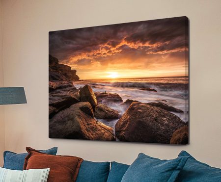 Warm sunset glowing over a calm sea with soft light across the horizon