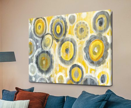 Abstract Circles Crop canvas of layered yellow, grey and cream circles displayed above a navy sofa