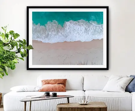 Framed coastal seascape of turquoise ocean meeting golden sand under a clear blue sky