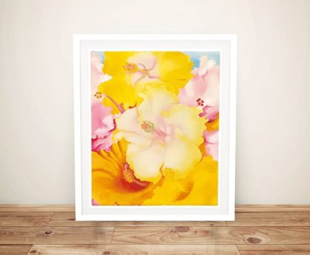 Georgia O'Keeffe Hibiscus framed print featuring vibrant yellow and soft pink floral blooms in a white frame on timber floor