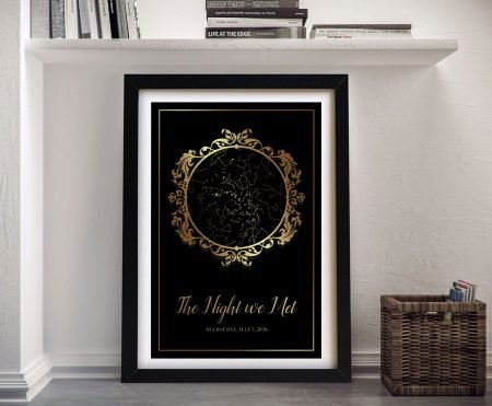 Black and gold ornate vintage star map in framed paper print propped on shelf below art books, a personalised celestial artwork