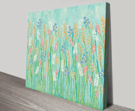 Walk in the Wildflowers canvas print featuring whimsical white, coral and orange flowers on turquoise background leaning on timber floor