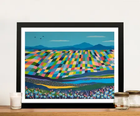 It's a Wonderful World framed print showing colourful patchwork fields, blue mountains and wildflowers resting on timber shelf
