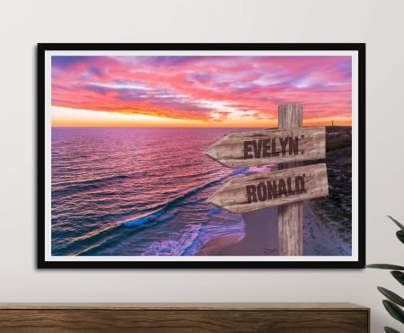 Carved signpost before a vivid orange Guilderton sunset over the coast