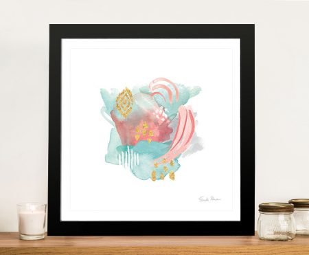 Farida's Abstract IV watercolour print in pink, teal and gold, black framed square artwork on a timber shelf