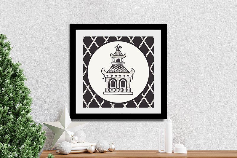 Black and white chinoiserie pagoda framed print by Mary Urban styled on console with Christmas tree and decorations