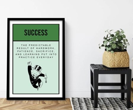 Framed print of a Success Monopoly-style motivational quote laid out as a Community Chest card with a dark-green header, mint panel and typewriter-style definition