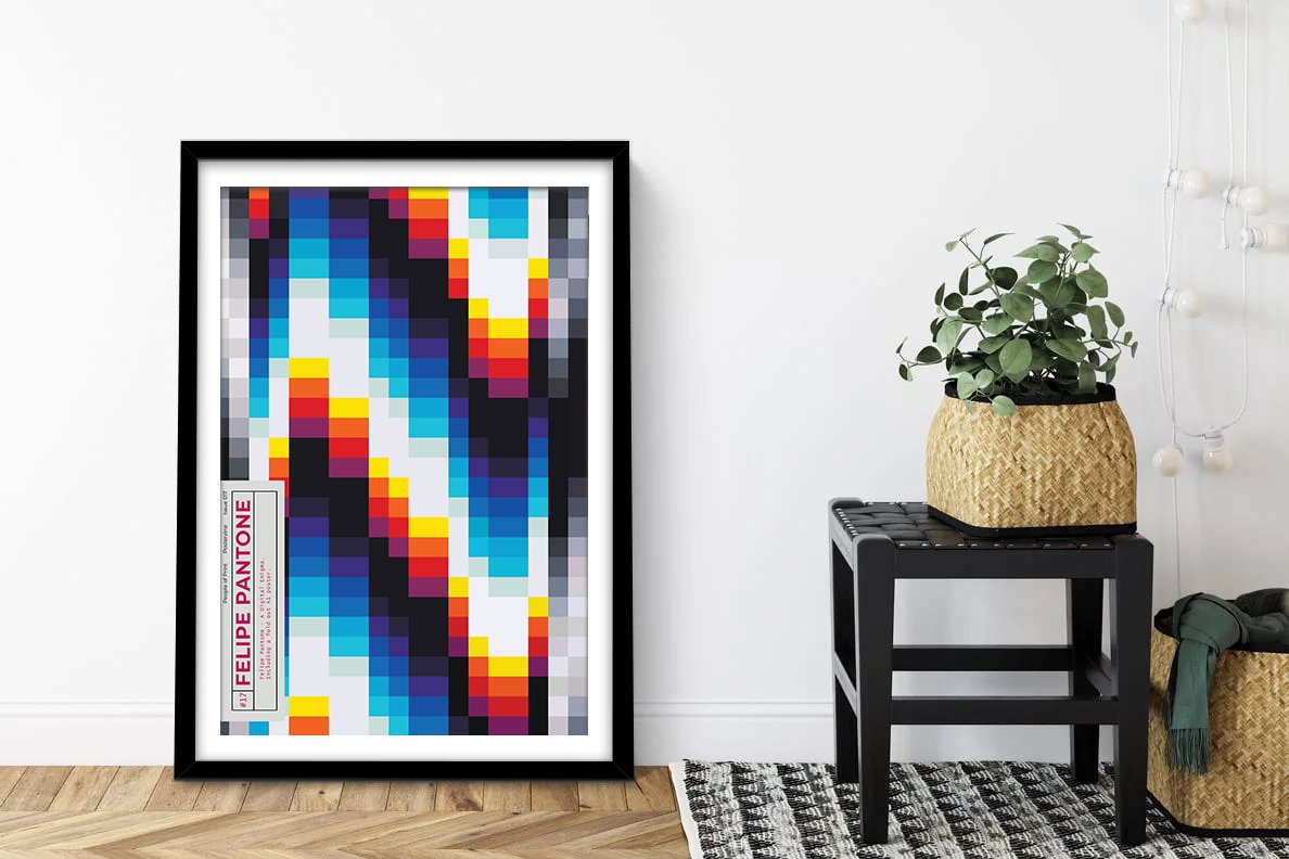 Felipe Pantone Posterzine framed print with pixelated rainbow geometric design leaning against white wall beside woven planter and stool