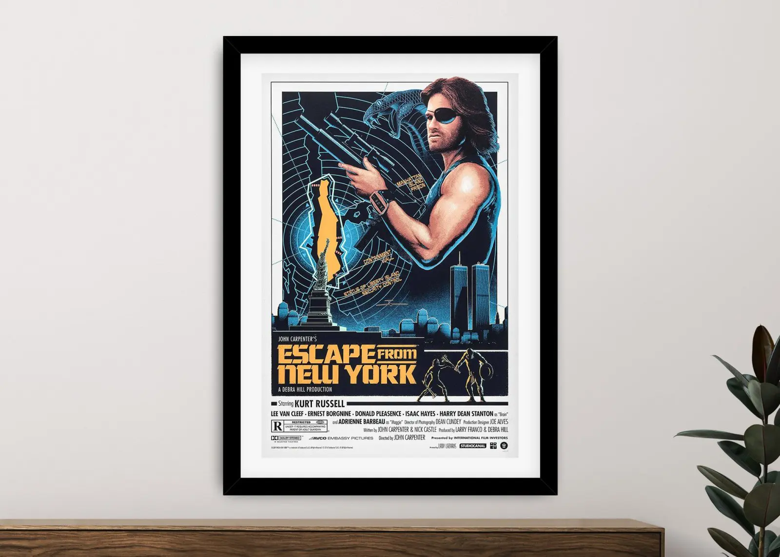 Framed Escape from New York film poster featuring Kurt Russell as Snake Plissken in blue and yellow tones on a neutral wall