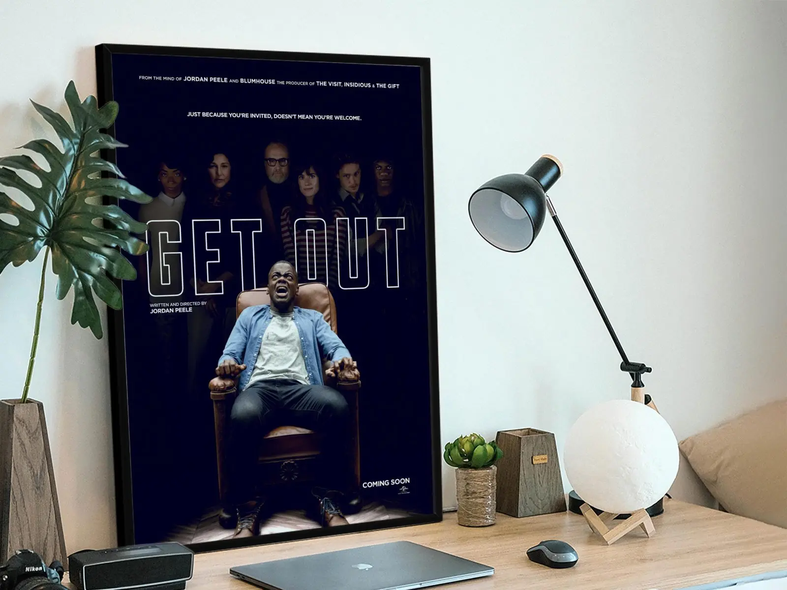 Get Out movie poster framed print on desk featuring Daniel Kaluuya screaming in armchair against dark background