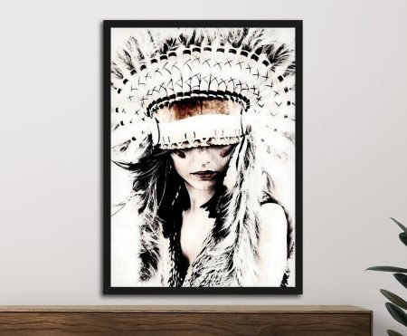 Framed black and white portrait of a girl wearing a feathered headdress, hung above timber sideboard with rubber plant