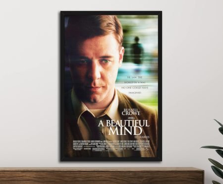 Framed A Beautiful Mind movie poster featuring Russell Crowe displayed above a wooden console with green plant