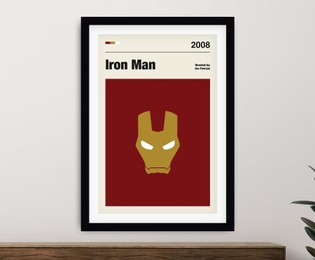 Iron Man framed movie poster on a wall above a timber sideboard with rubber plant