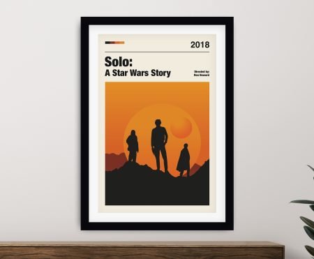 Minimalist Solo A Star Wars Story film poster framed in black above a timber console with rubber plant