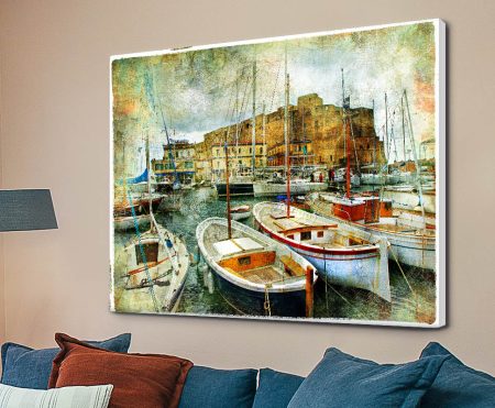 Boats in the Harbour vintage-style canvas print displayed above blue sofa on beige living room wall