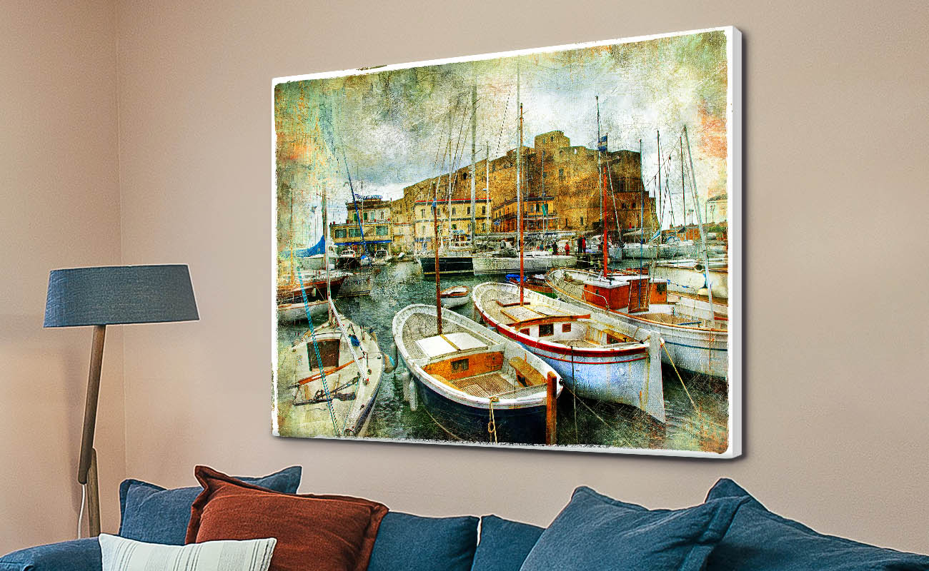 Boats in the Harbour vintage-style canvas print displayed above blue sofa on beige living room wall