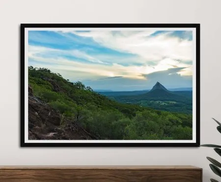 A framed canvas print of Glass House Mountains showing the tall peak, forested ridges and warm horizon light, ideal as a nature‑inspired art gift.